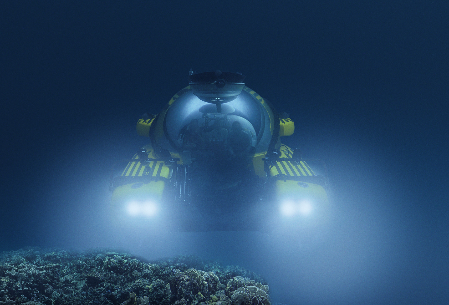 An image of a submarine, with lights lit, underwater.