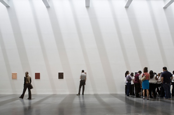 Museum visitors view artwork in gallery space.