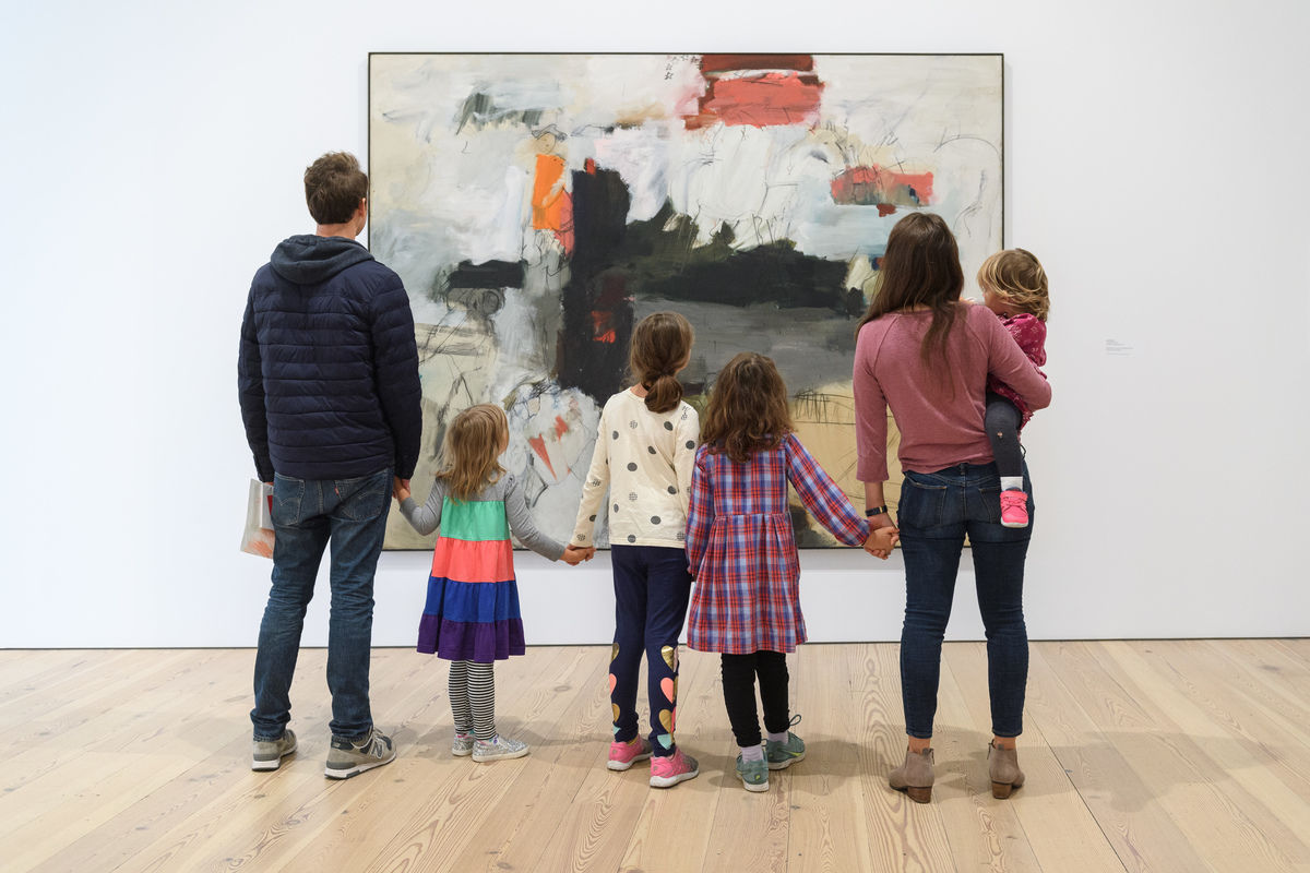 A family views an artwork in a gallery.